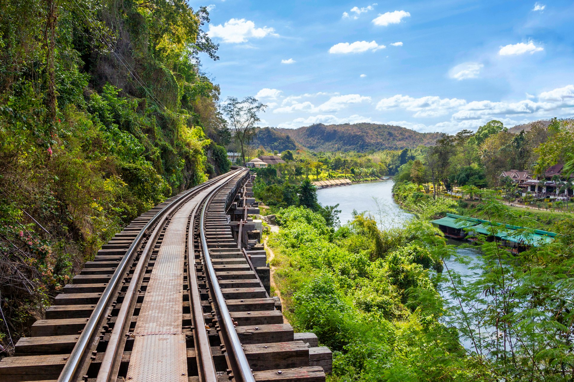 a train traveling down train tracks next to a river